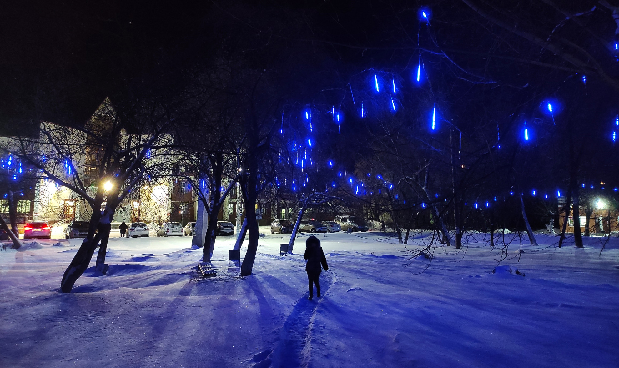 Тающие ярко-синие сосульки стекают по веткам деревьев у сквера Привокзальный. Такие необычные новогодние сосульки не первый год украшают яблоньки у “Вентпрома”, а теперь вот засверкали и у вокзала. И приехавшего в Артемовский гостя будут встречать завораживающая синева деревьев у вокзала, сопровождать звезды по улице Ленина и радовать сияющие шары и гирлянды на площади и у завода “Вентпром”.