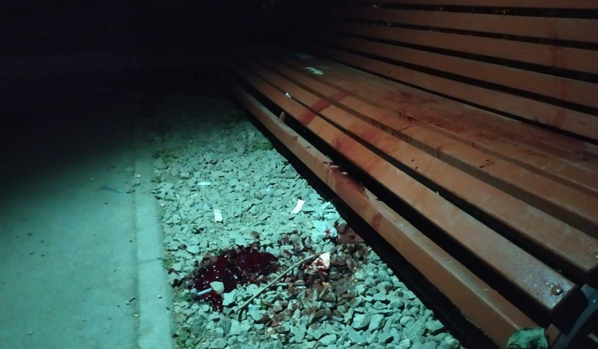 На уличной скамье и асфальте остались большие пятна крови.