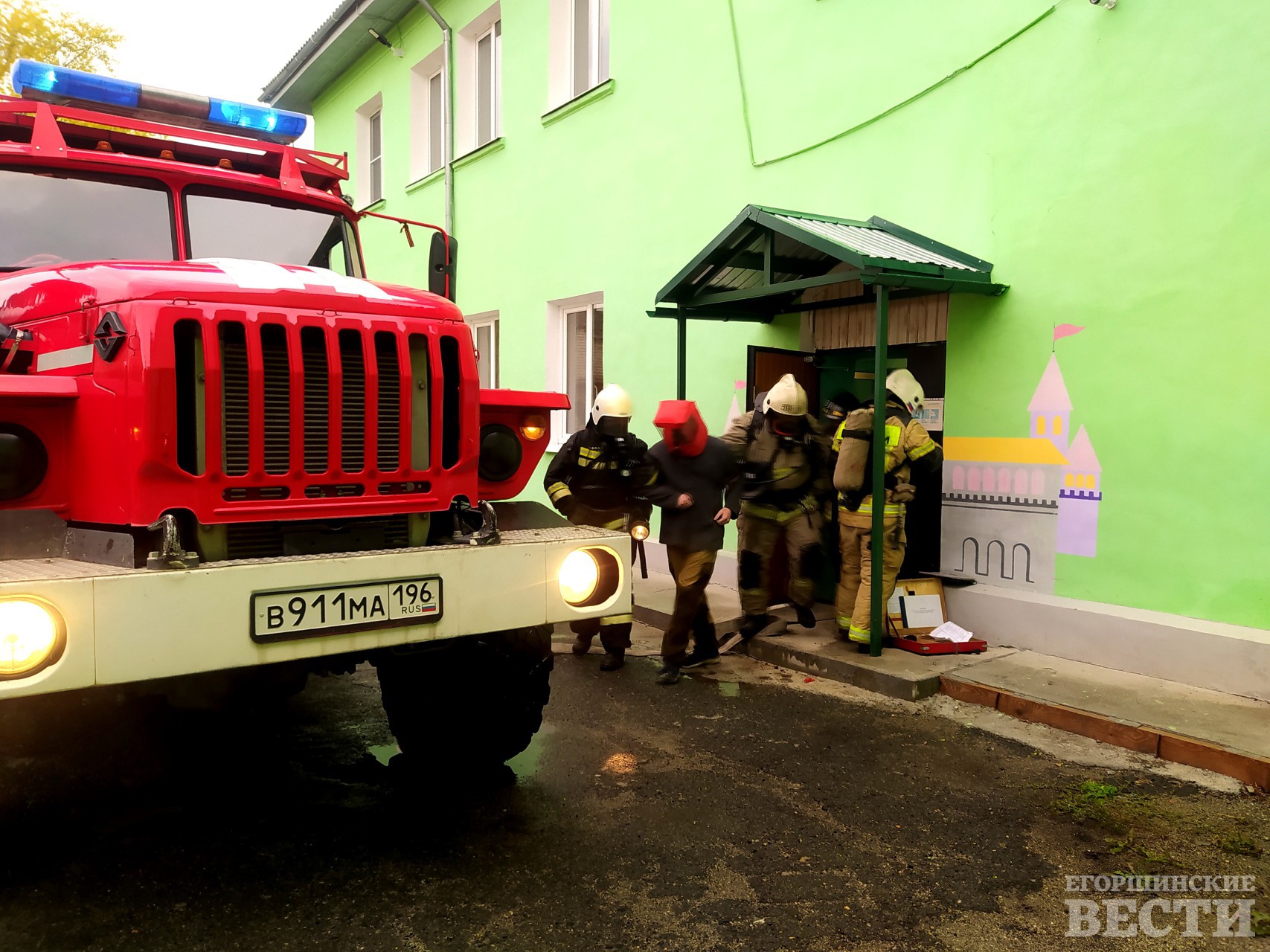 Спасатели эвакуируют из задымленного здания сотрудника детского учреждения. Фото: 54 ПСО