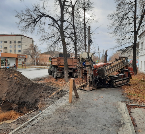 Машина, похожая на маленькую ракетную установку, производит прокол под дорожным полотном.