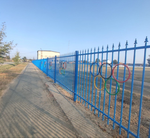 Забор украсили разноцветными олимпийскими кольцами.
