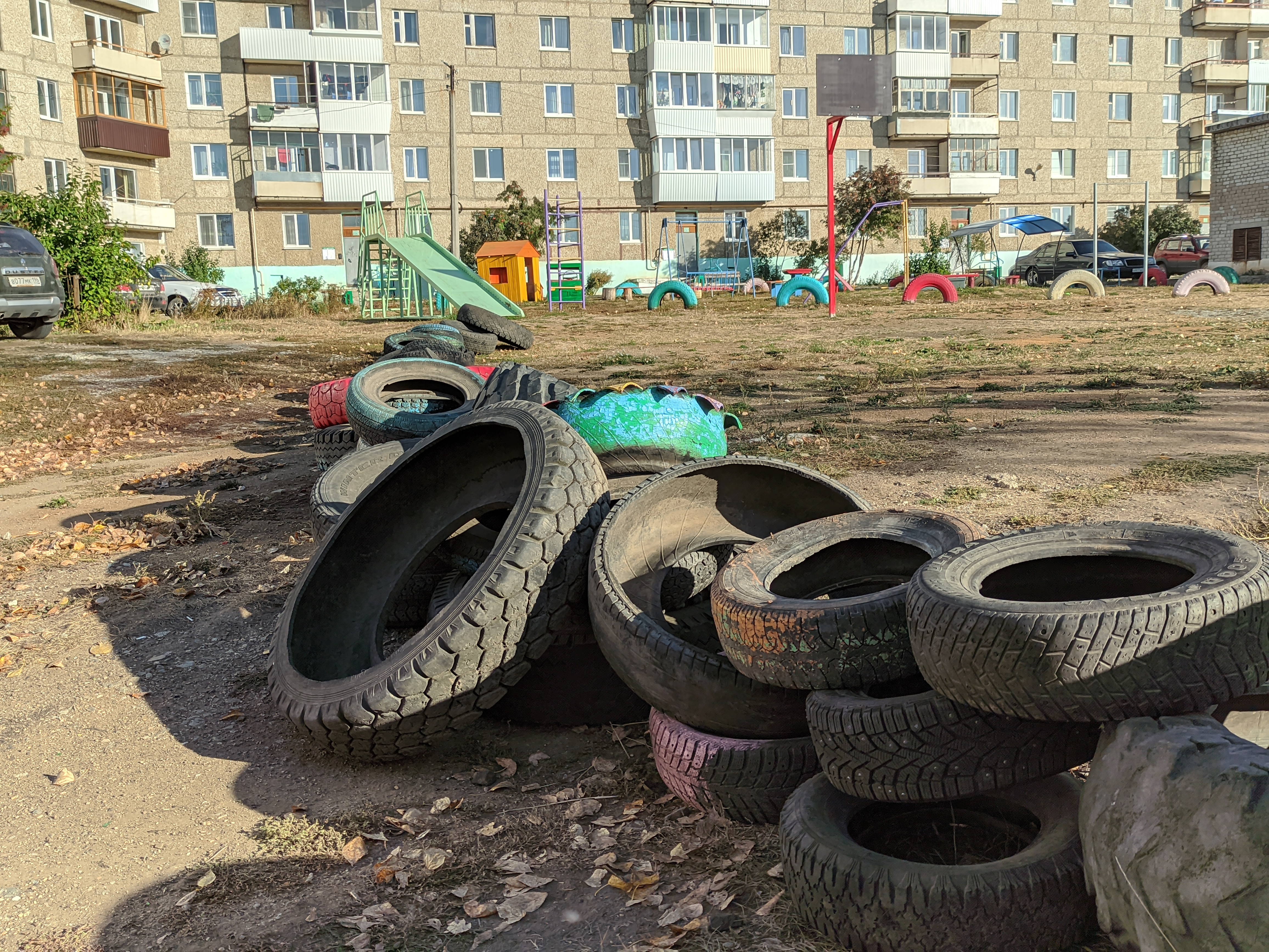 Куда выкинуть покрышки. Покрышки во дворах. Старые шины. Вкопанные шины. Шины вкопанные в землю.