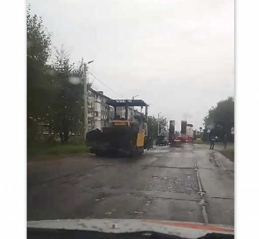 На дорогу по ул. Достоевского подрядчик укладывает асфальт в дождь. 